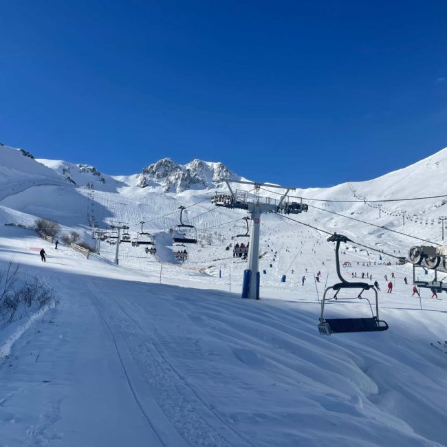 Montañas con nieve y telesilla