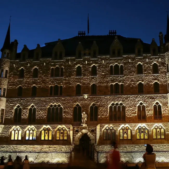 Fachada iluminada de noche de Casa Botines de Gaudi